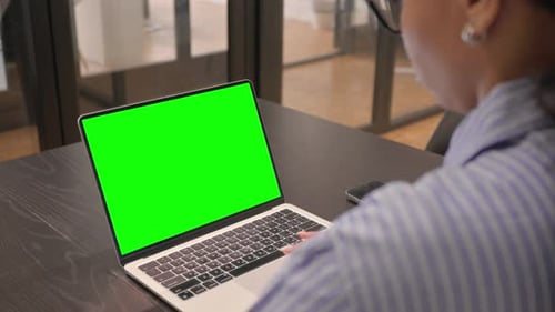 African Woman Working on Laptop with Green Screen