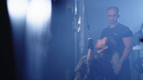 A Woman Trains Her Hands on a Simulator in the Gym