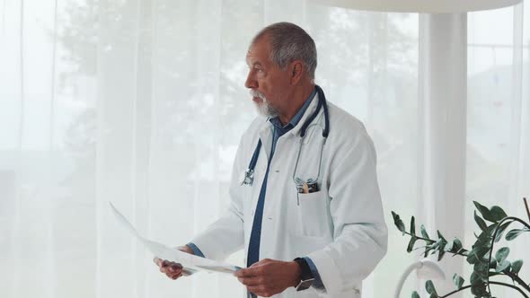 Senior doctor examines chest x ray radiography film in hospital office ...