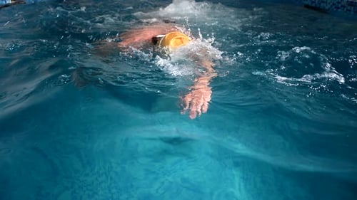 Vista submarina de un nadador profesional entrenando en una piscina, 120 fps, cámara lenta, RAW