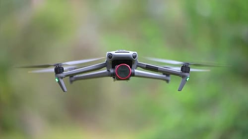 Drohnenflugzeug mit verschwommenen, schnell rotierenden Propellern und in der Luft fliegender Videokamera