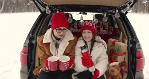 Family Sitting in a Car Among Winter Forest