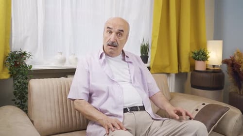 Old man looking at camera confused.