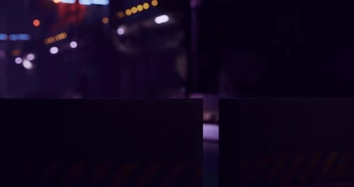 Nighttime Cityscape with Illuminated Buildings and Barriers in Foreground