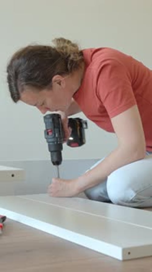 Woman Assembling Furniture at Home Using Power Drill