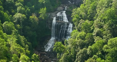Whitewater Falls with Falling Down Clear Water From Rocky Boulders Between Green Lush Woods in