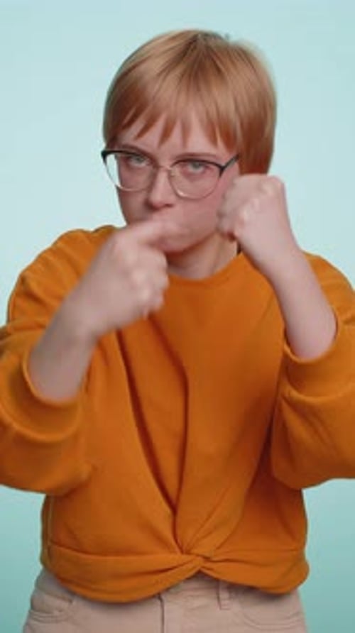 Serious Young Woman Threatens with Fists, Studio Shot