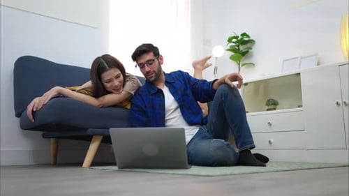 Couple Relaxing at Home with Laptop Computer
