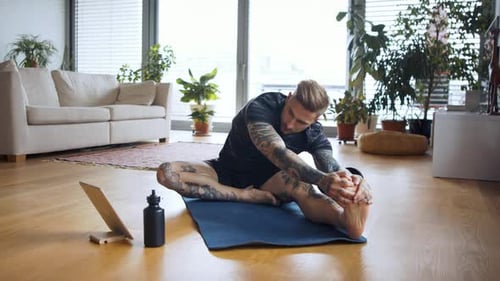 Front View Portrait of Man with Tablet Doing Workout Exercise Indoors At