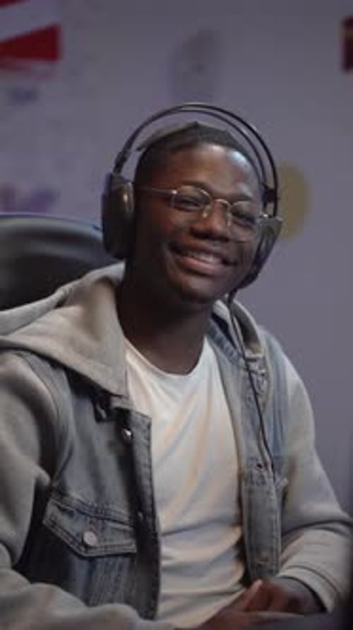 Vertical Video Portrait of Young Black Man Smiling and Laughing Looking to Camera in His Home Studio