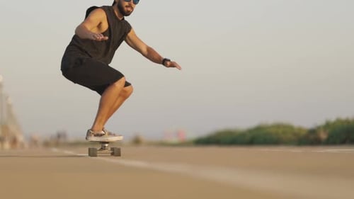 Adult Bearded Man Skateboarding on the Street on His Knees Bent