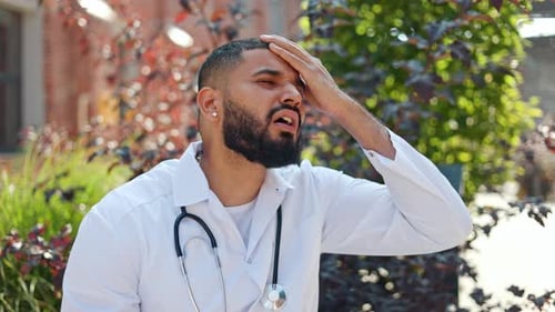 Stressed Doctor Touching Forehead Outdoors During Daytime
