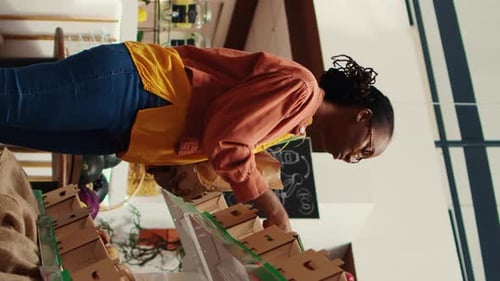 Vídeo vertical: Un cliente habitual pone verduras ecológicas de cosecha propia en una bolsa de papel