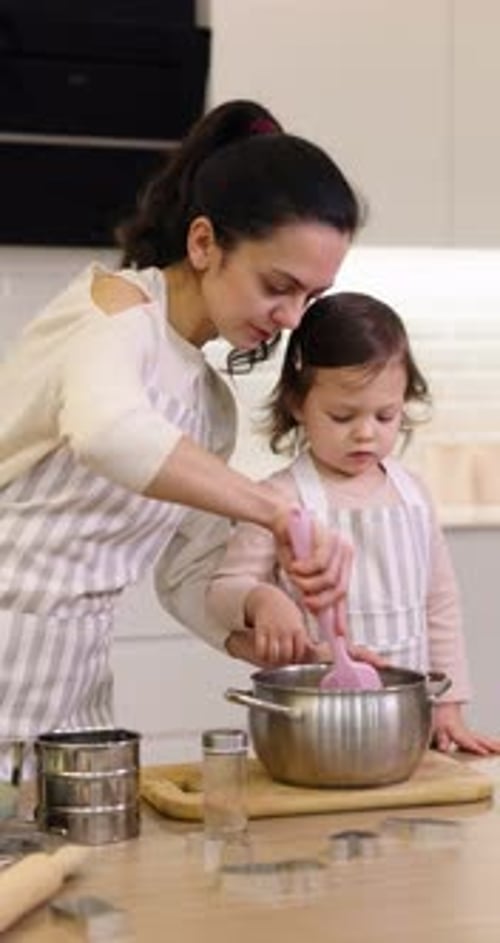 Woman and Child Mixing Ingredients in Kitchen