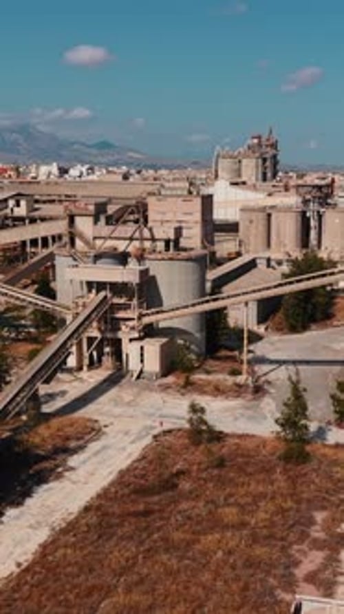 Drone Flying Over Abandoned Industrial Cement Factory on Sunny Day