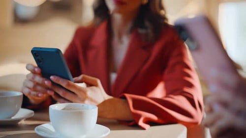 Manicured Hands Holding Cellphones in Cafe Closeup Elegant Two Businesswomen
