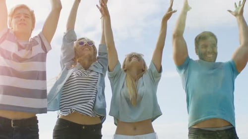 Multi-Ethnic Group of Diverse Diverse Young People Jump and Throw Colorful Powder in the Air in Cel