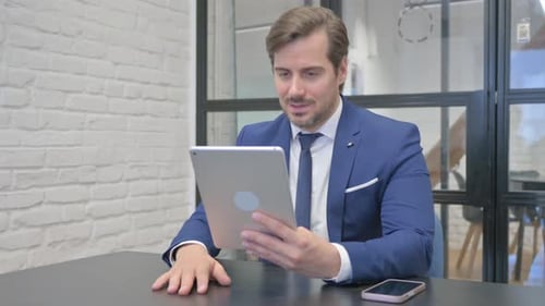 Professional Man Conducting Video Call on Tablet