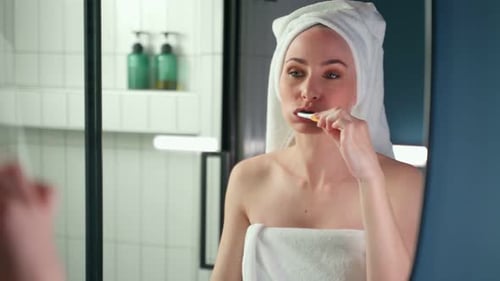 Woman Brushing Teeth in Modern Bathroom