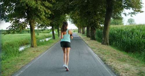 Woman Jogging on Road in Rural Area