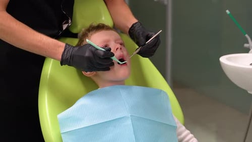 Child Having Teeth Examined by Dentist in Office