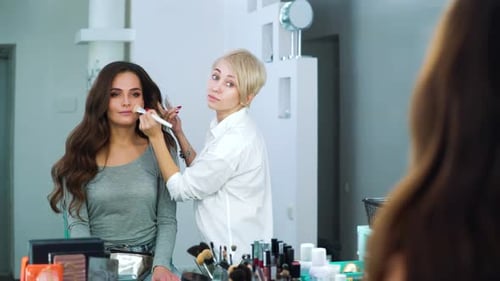 Makeup Artist Applying Makeup on a Beautiful Woman