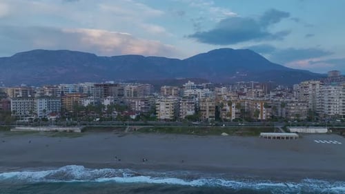 Aerial Video Coastal City with a Vibrant Sunset Sky Reflecting on the Azure Sea Below