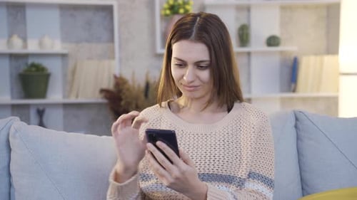 Woman Using Smartphone on Couch at Home