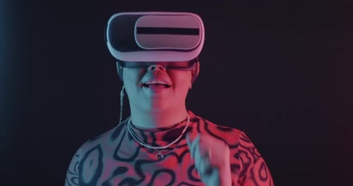 Woman Interacts with Virtual Reality Headset, Smiles