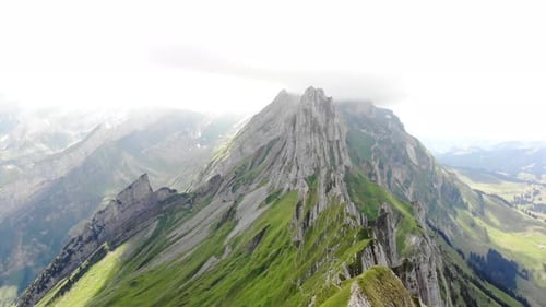 Aerial flyover over the cliffs of Schafler ridge in Appenzell, Switzerland towards Altenturm peak on