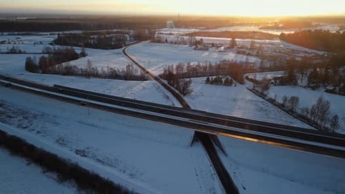 Golden Sunrise Over Snowy Highway and Countryside