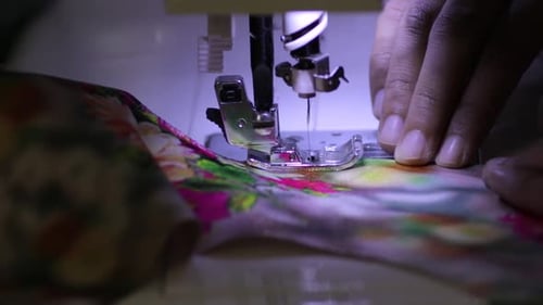 Schneiderinnen, die eine Nähmaschine bedienen, verarbeiten in Zeitlupe, schnelles Nähen, Nadelarbeit im Ma