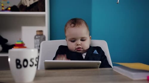 Infant Uses Tablet at Table Indoors