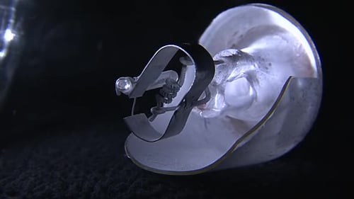 Gros plan d'un tube fluorescent cassé avec un filament exposé et des composants endommagés