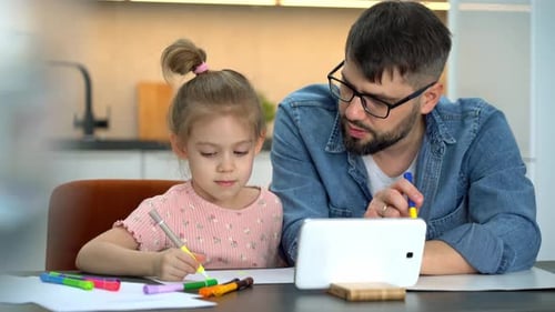 Father and Daughter Drawing with Markers at Home