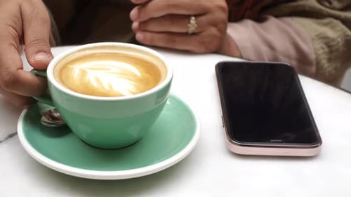 Frauen halten eine Kaffeetasse