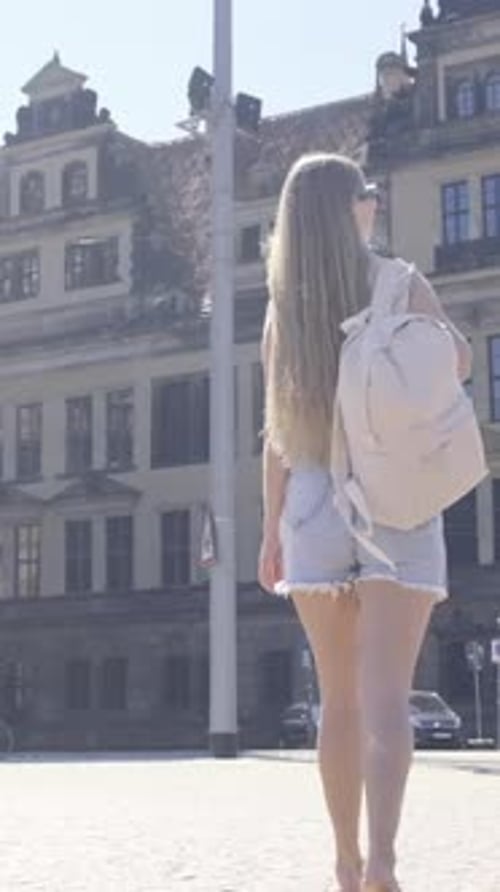 A Woman Walks Barefoot on a Cobblestone Street Admiring Architecture Vertical Video