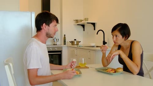 Couple Eating and Talking at Kitchen Table