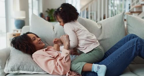 Mother and Child Playing on Sofa at Home