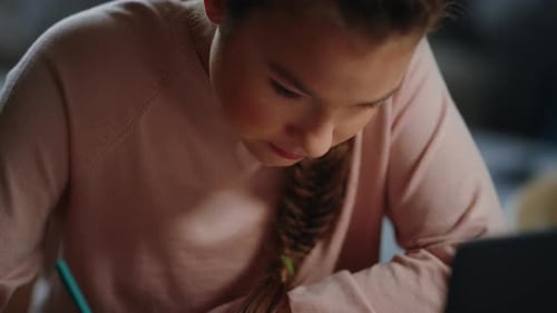 Focused Girl Studying and Writing Math Equations