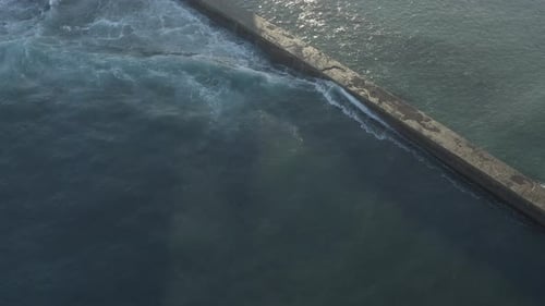 Ocean Waves Crashing Over Pier Aerial