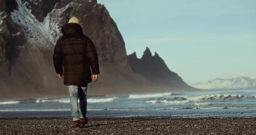 Back View Of Man Exploring Majestic Coastal Landscapes