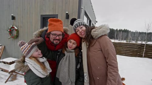 Happy Family Posing in Front of House in Winter