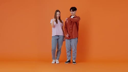 Woman Shows Thumbs Up While Asian Man Shows Thumbs Down