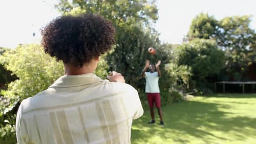 Friends Playing Football in a Sunny Backyard