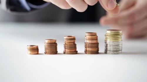 Businessman hands carefully stacking euro coins symbolizing savings and financial wealth