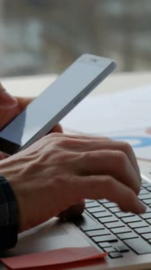 Adult Hands Typing and Scrolling Phone at Desk