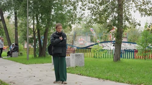 Girl Alone Pondering Thoughtful Girl in Rainy Park Young Woman Appears Reflective in Gloomy Weather