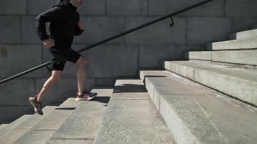 Man Running Up Stone Stairs in the Daytime