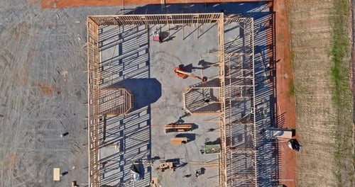 Aerial view of elevator shaft for concrete block building under construction work on workers